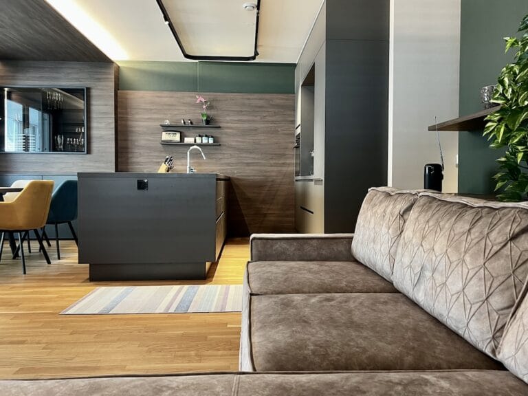 Graue Wandverkleidungen verbinden Küche mit Essenbereich
